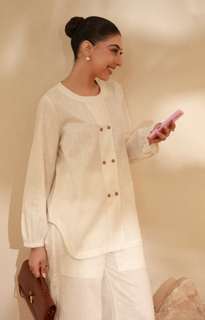 Close-up profile of an off-white double-breasted buttoned tunic.
