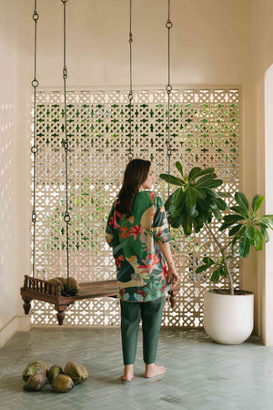 Woman sitting on a wooden swing in a room with decorative elements and plants.