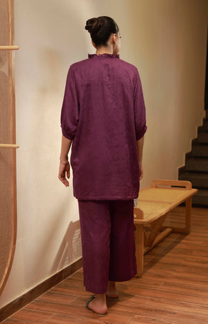 Back view of the plum purple matching set showing the ruffled collar and loose-fit tunic length.
